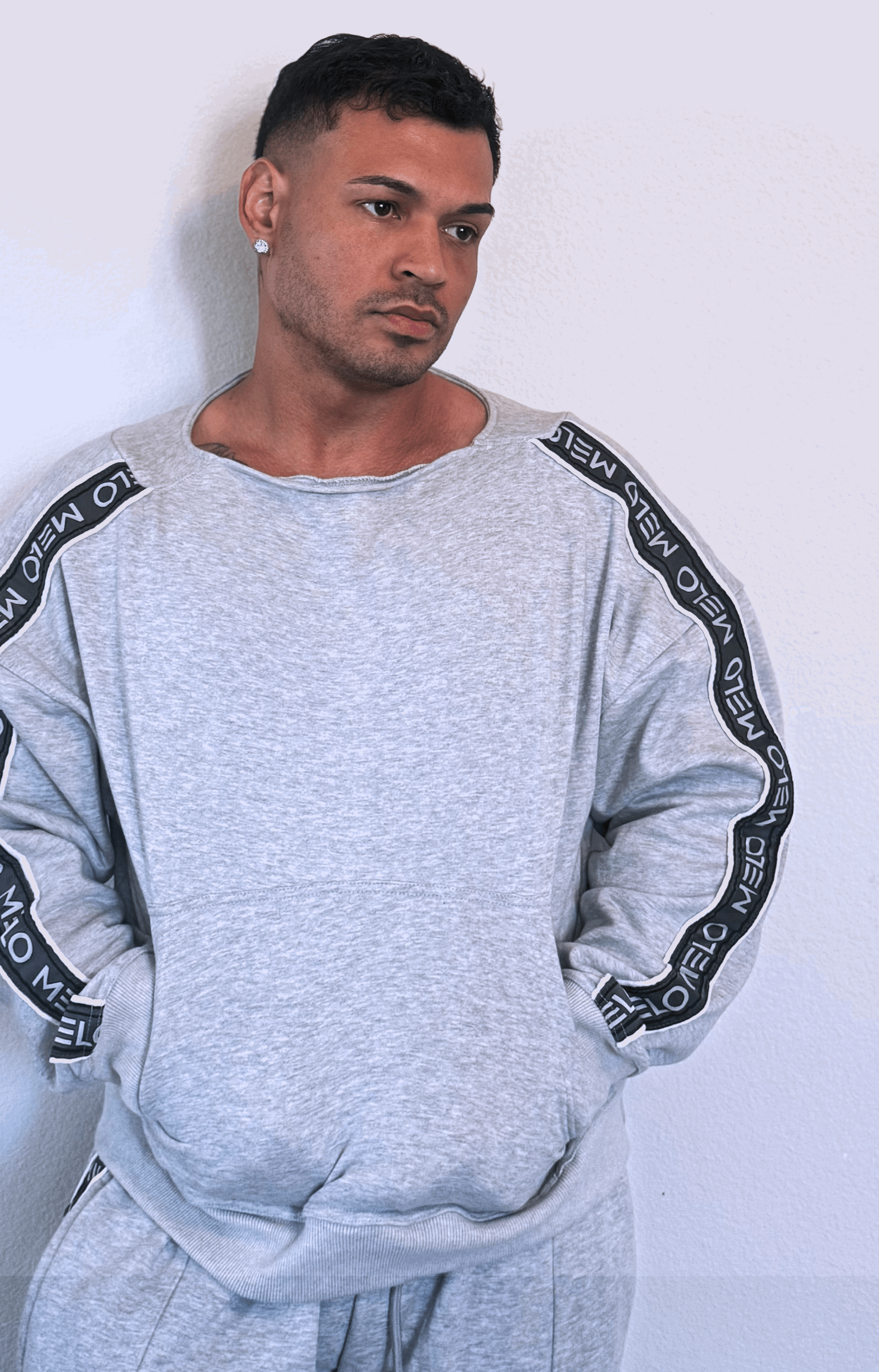 GOAT SWEATSUIT🐐 model showcasing a grey three-piece outfit featuring a wide-neck sweater and loose pants.