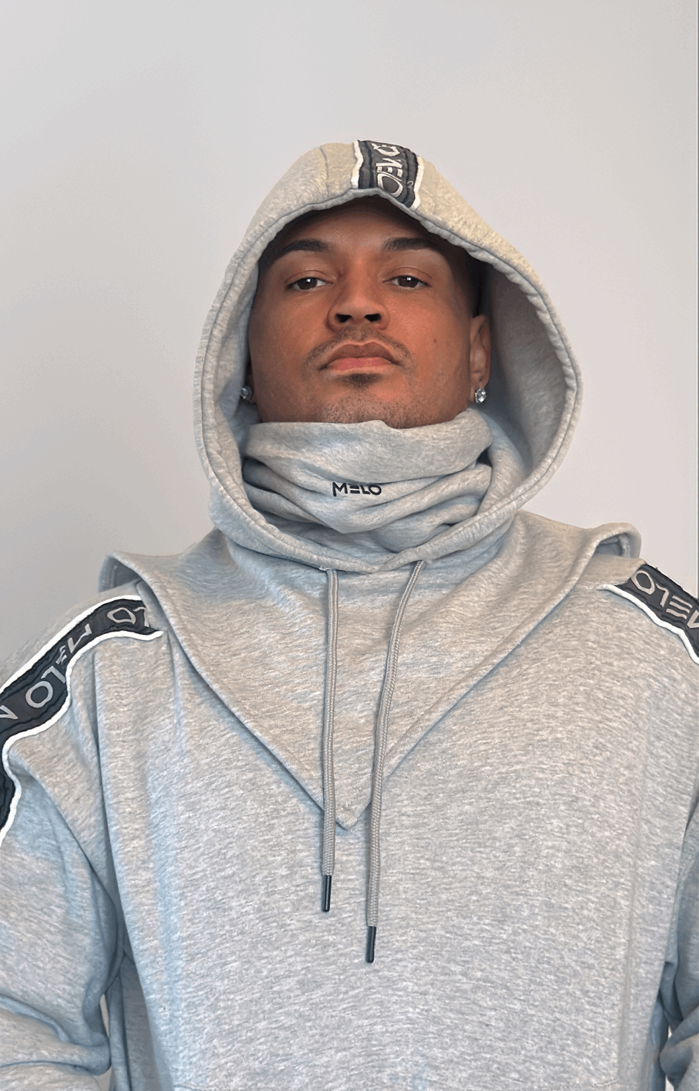 Man wearing a stylish gray GOAT SWEATSUIT🐐 with a hood and funnel neck for added versatility.