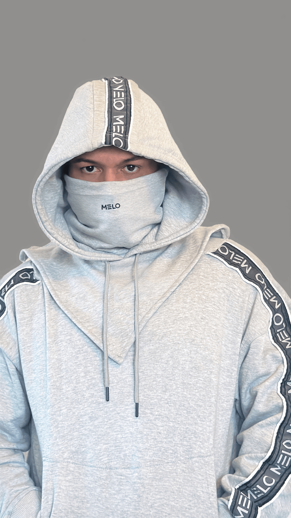 Model wearing GOAT SWEATSUIT🐐 with a hood and funnel neck design for versatile wear.