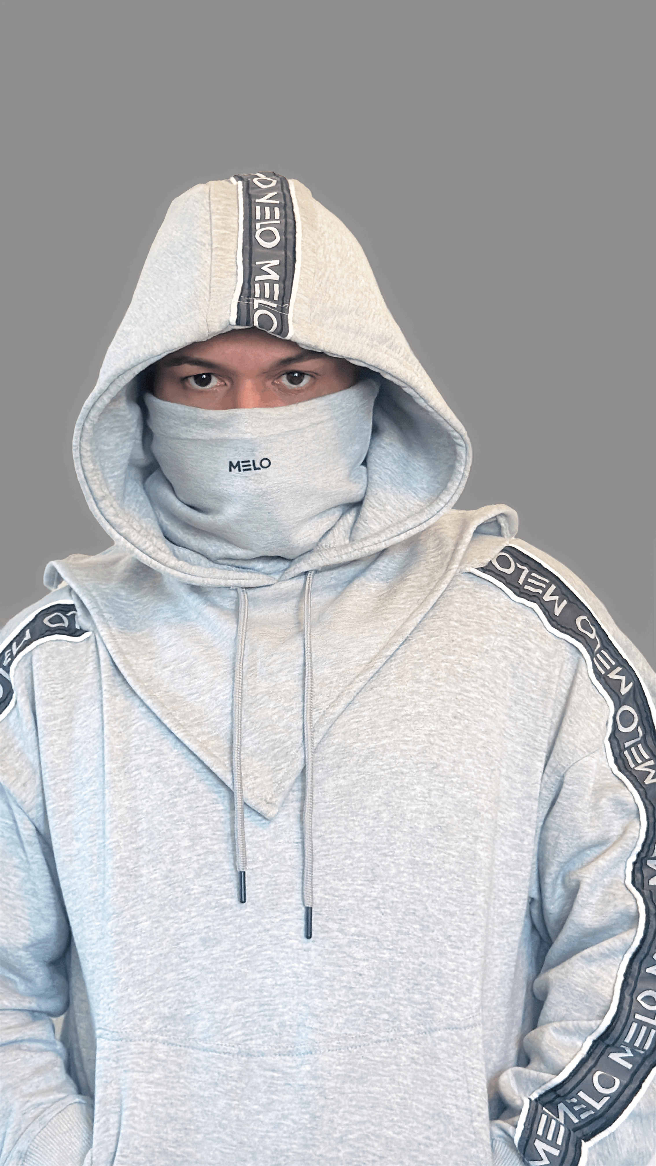 Model wearing GOAT SWEATSUIT🐐 with a hood and funnel neck design for versatile wear.
