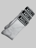 White socks with black 'Melo' branding on a light gray background