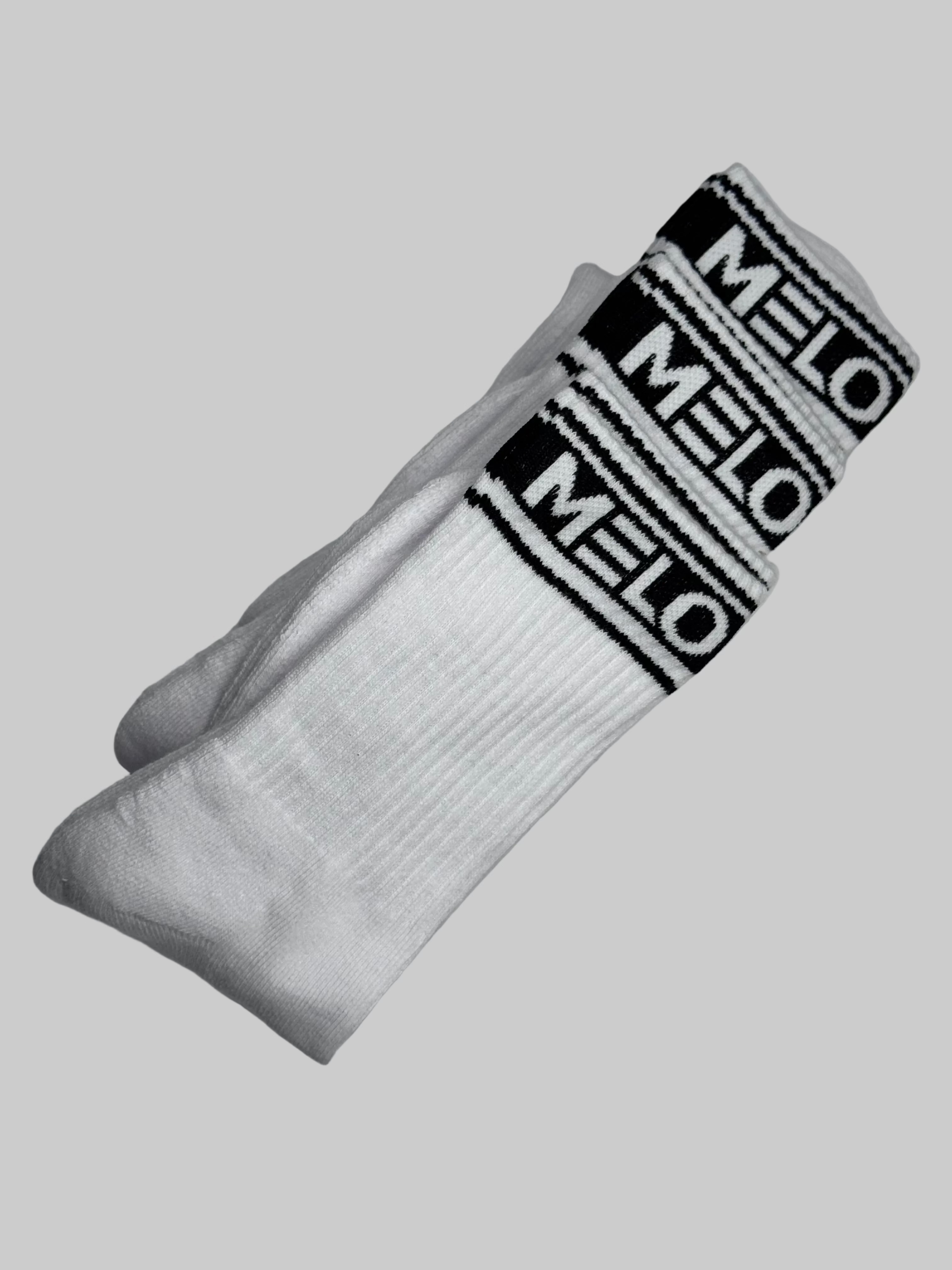 White socks with black 'Melo' branding on a light gray background
